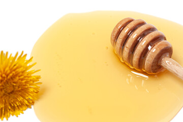 Wooden dipper with honey and dandelion isolated on a white background. Golden organic floral honey...