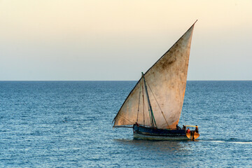 large african sailing dhow on the ocean with a distant blue horizon