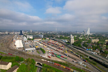 Fototapeta premium Aerial view of City of Basel with highway and railway track field on a blue cloudy spring day. Photo taken April 27th, 2022, Basel, Switzerland.