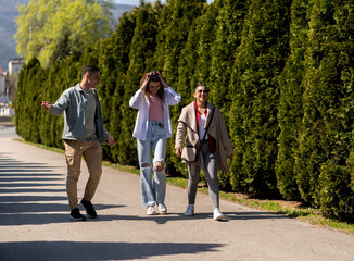 Portrait of three smiling friends talking together standing on the street