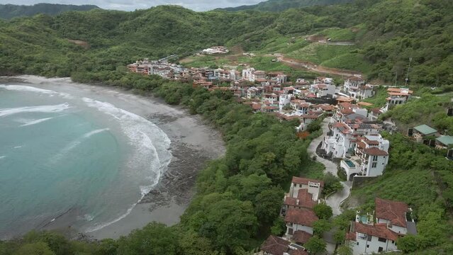 Danta Beach in Guanacaste, Las Catalinas town, Costa Rica. aerial drone shot tropical beach and hill settlements