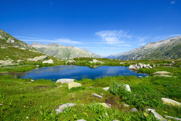 Beautiful landscape panorama by the lake with mountains in the background. Photograph was taken at a mountain pass in Switzerland in Swiss Alps.