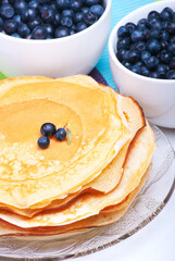 Pancakes and blueberries in two white plates