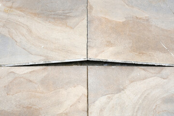 Selective focus picture of tiles lifted and  broken at the floor