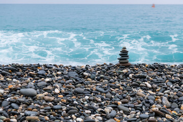 Fototapeta na wymiar stacked stones, tower or pyramid of stones on the beach, balance, Sea waves background （Hualien, Taiwan）