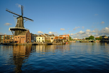 Fototapeta na wymiar HAARLEM, NETHERLANDS - MAY 24, 2022: The famous Adriaan Windmill on the river De Spaarne on a clear day.