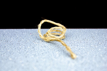 Winding the rope around your finger.Small rope.Strong thin thread rope on a black background close-up.