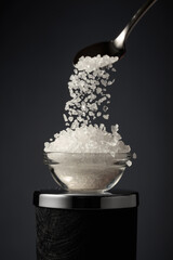 Sea salt is poured into a small bowl.