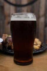 Brew. Closeup view of an amber ale beer on the wooden table.