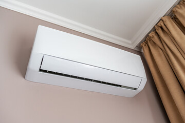 White air conditioner on the wall in the room.