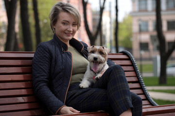 Woman sitting in park with jack russell terriers