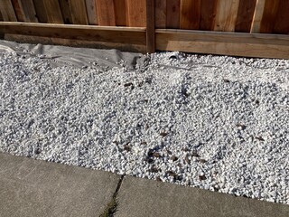 Spreaded white gravel rocks during sidewalk strip landscaping projects