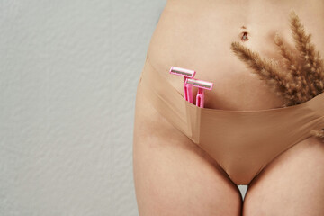 female beautiful body in lingerie. in women's panties, pink razors and fluffy twigs. skin care,...