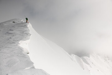 gorgeous view on skier in bright jacket with on splitboard on mountain at winter day