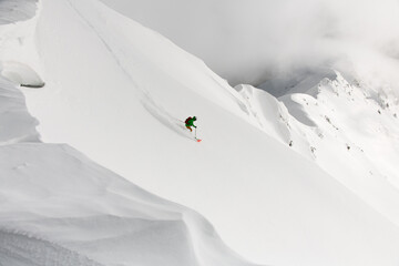 Beautiful view from drone on man freerider riding down from top of ridge.