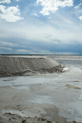 Industrial. View of the natural white salt flats and open cast mining pit under a beautiful sky.
