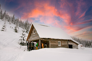 beautiful wooden house in the snowy mountains with tourists near it