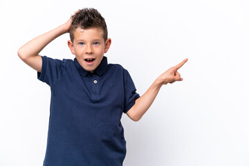 Little caucasian boy isolated on white background surprised and pointing finger to the side