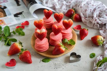 Romantic breakfast for lovers: pink pancakes with strawberries. Fruit pancakes on a gray background. Close-up