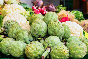 Fototapeta premium Fresh green artichokes and cauliflower on a market