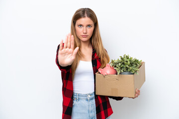 Young caucasian woman making a move while picking up a box full of things isolated on white...