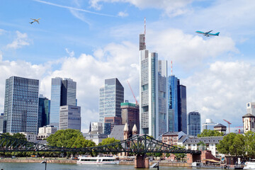 Frankfurt - European city skyline. Airplanes are flying in high flight. Skyscraper buildings in...