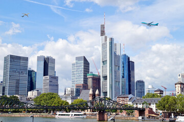 Fototapeta premium Frankfurt - European city skyline. Airplanes are flying in high flight. Skyscraper buildings in Germany on blue sky background. Business and Financial Center Frankfurt Main. Travel Destinations concep