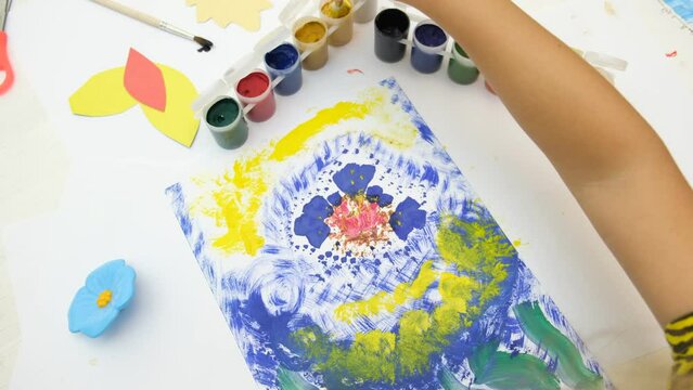 Little girl coloring colorful abstract with flowers. Early development.  Children's creativity . The concept of a happy childhood.