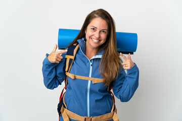 Naklejka premium Middle age mountaineer woman with a big backpack over isolated background giving a thumbs up gesture