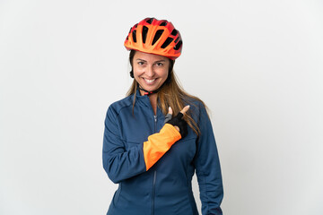 Middle age cyclist woman isolated on white background pointing to the side to present a product