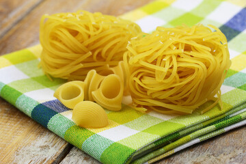 Uncooked Italian pasta on kitchen cloth closeup
