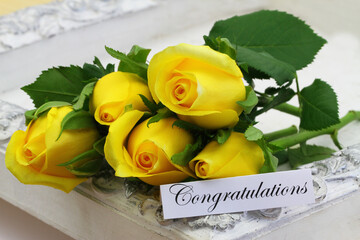 Congratulations card with five beautiful yellow roses on vintage white tray
