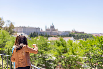 Set of people at the viewpoint of the Royal Palace of Madrid and the Almudena Cathedral on a clear day with blue sky, in Spain. Europe. Photography.