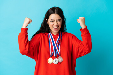 Young woman with medals isolated on white background celebrating a victory