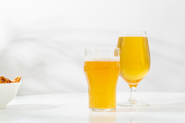 Two mug with light beer on light table copy space snack craft