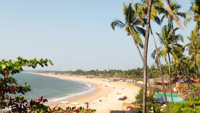 4K time lapse footage at the Sinquerim Beach in Goa with tourists enjoying the  the ocean view and watersport activities in the evening