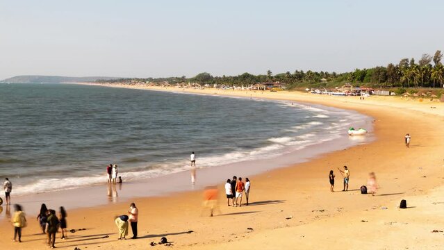 4K time lapse footage at the Sinquerim Beach in Goa with tourists enjoying the  the ocean view and watersport activities in the evening