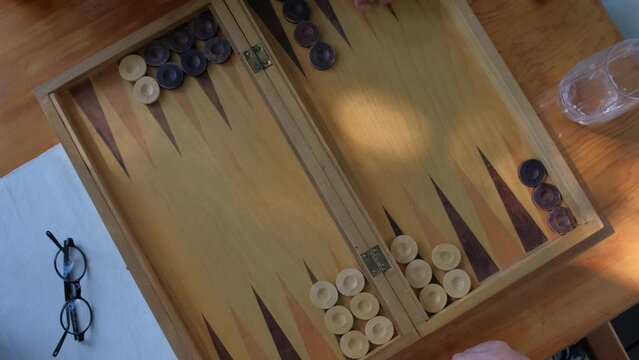 Two man playing backgammon and rolling dice