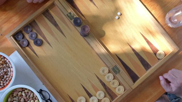 Two man playing backgammon and rolling dice