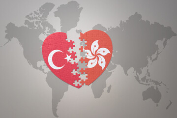 puzzle heart with the national flag of turkey and hong kong on a world map background. Concept.