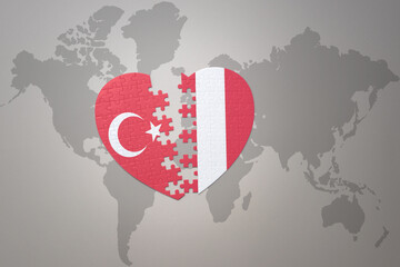 Fototapeta premium puzzle heart with the national flag of turkey and peru on a world map background. Concept.