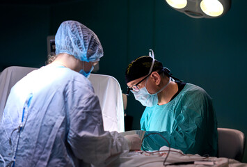 surgeon in a dark operating room during surgery