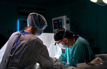 surgeon in a dark operating room during surgery