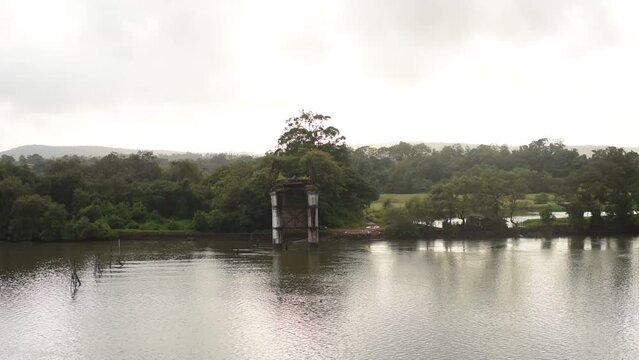 HD scenery of the Zuari river flowing through Borim village in Goa India with a view of a Chowgule Shipyard shipbuilding company and Borim Bridge