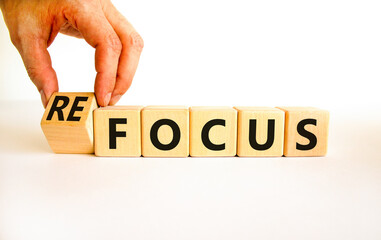 Focus or refocus symbol. Businessman turns wooden cubes and changes the concept word focus to...
