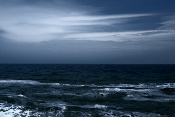 Landscape of blue ocean waves with beautiful clouds.