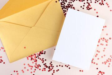 Invitation card mockup with golden envelope and white empty paper and red star shaped confetti