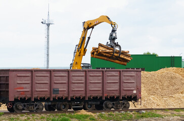 A crane unloads logs at a woodworking plant.