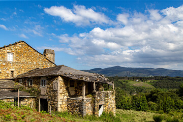 Fototapeta na wymiar Paisaje rural con una casona tradicional en mal estado y un bonito cielo. Suegos, Lugo, España.