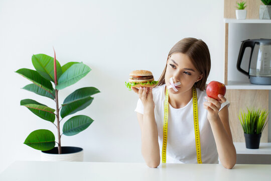 Portrait woman wants to eat a Burger but stuck skochem mouth
